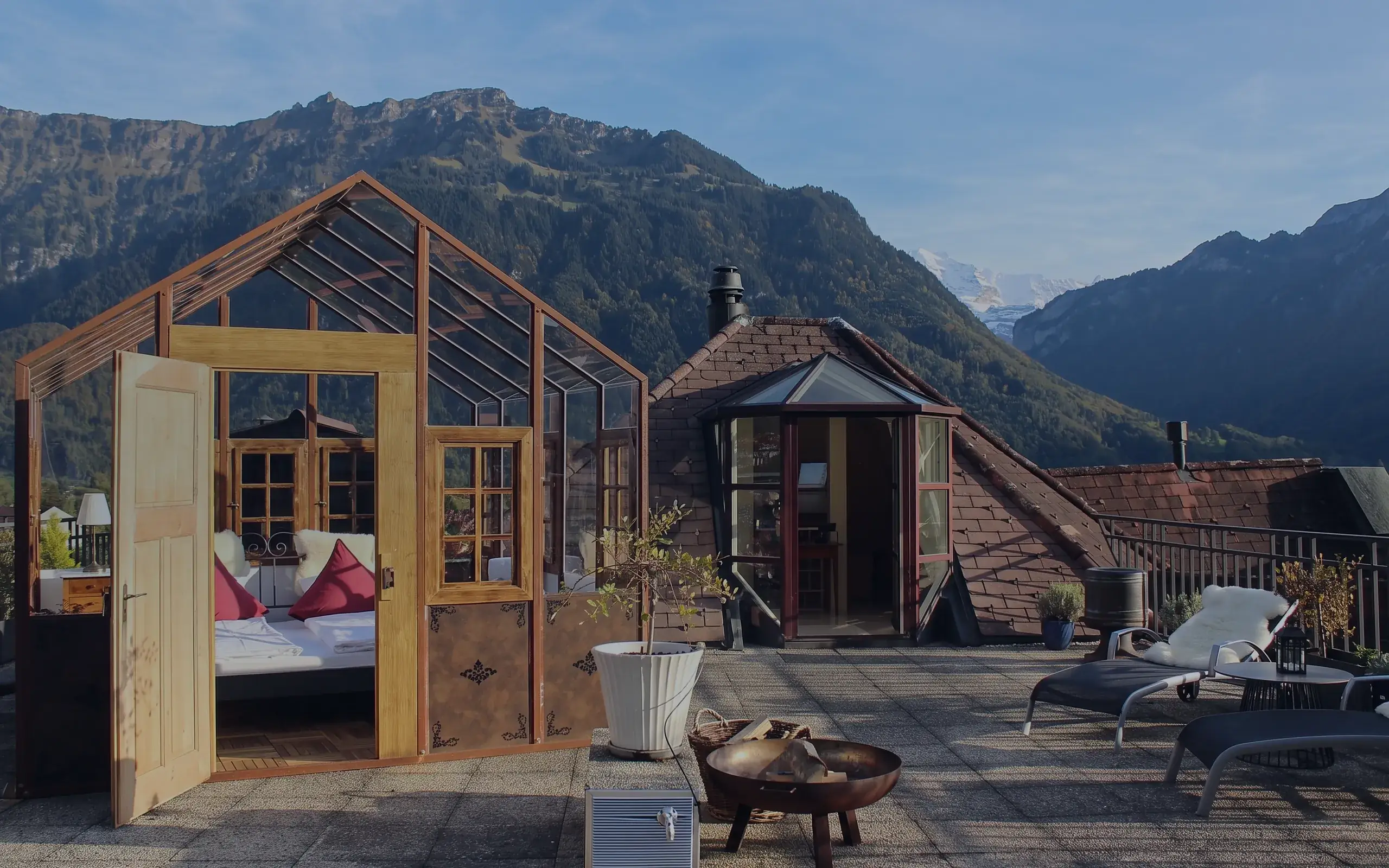 Glaspavillon mit Bett auf der Dachterrasse, dahinter Harder und Jungfrau