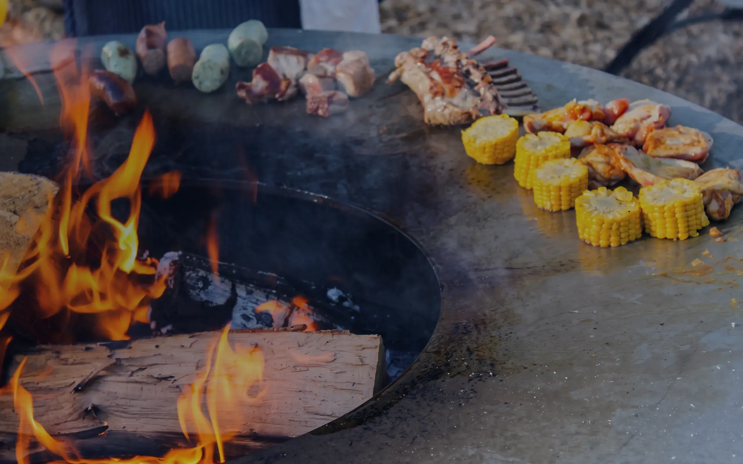 Feuerring mit Fleisch, Maiskolben und Gemüse