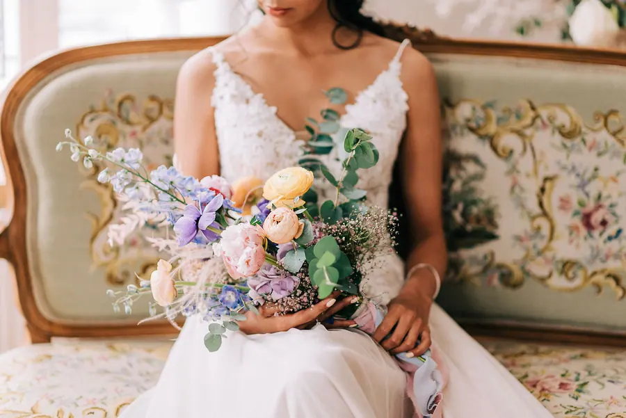 Braut mit Blumenstrauss auf einem Sofa mit Blumenmuster