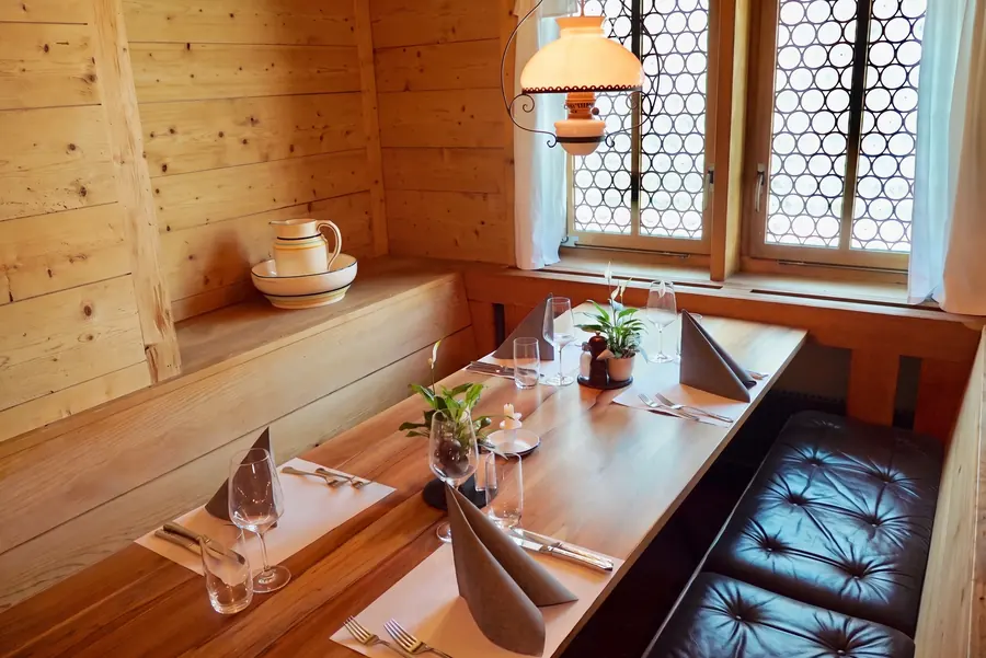 Gedeckter Tisch am Fenster in der Arvenstube des Chalet Beizli