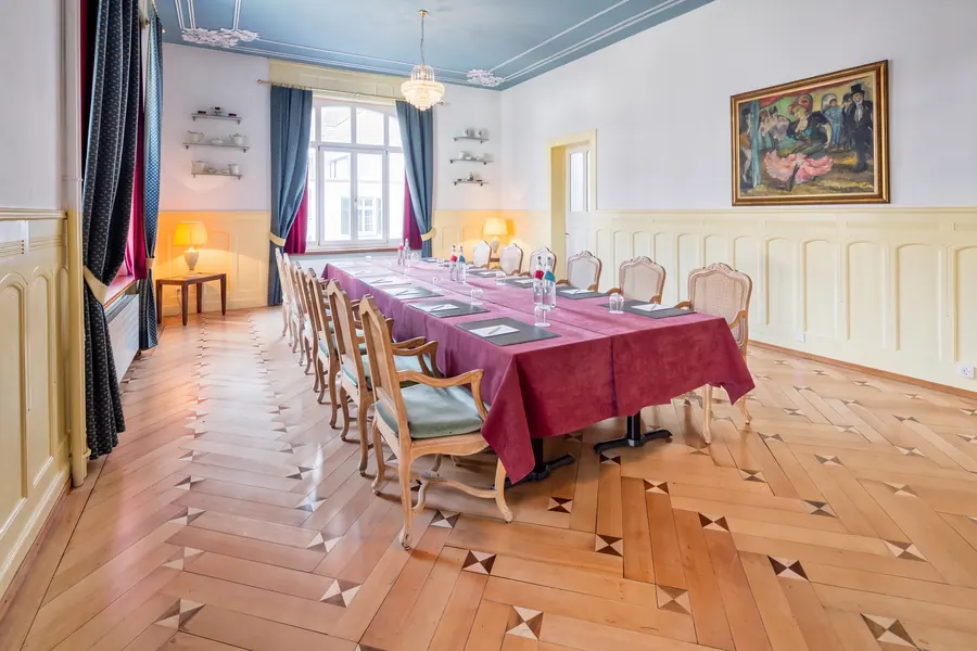 Jugendstilsaal mit langer Tafel und Parkett