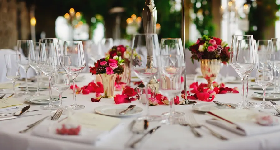 Festlich gedeckte Tafel mit roten Rosen und Kristallgläsern