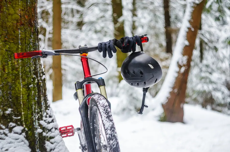 Mountain bike with helmet in the snowy forest