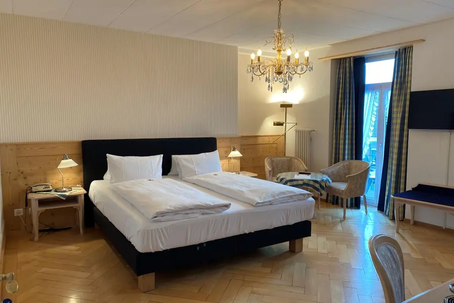 Classic-Doppelzimmer mit Kronleuchter und Sitzecke am Fenster