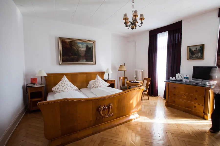 Classic-Zimmer mit Holzbett, Parkett und Kronleuchter