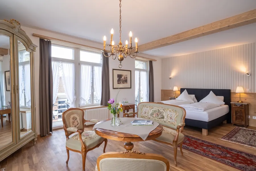 Suite mit Kronleuchter, Polstersesseln und grossen Fenstern