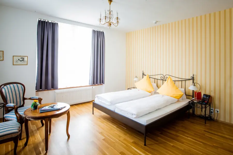 Zimmer mit gelb gestreifter Wand und Kronleuchter
